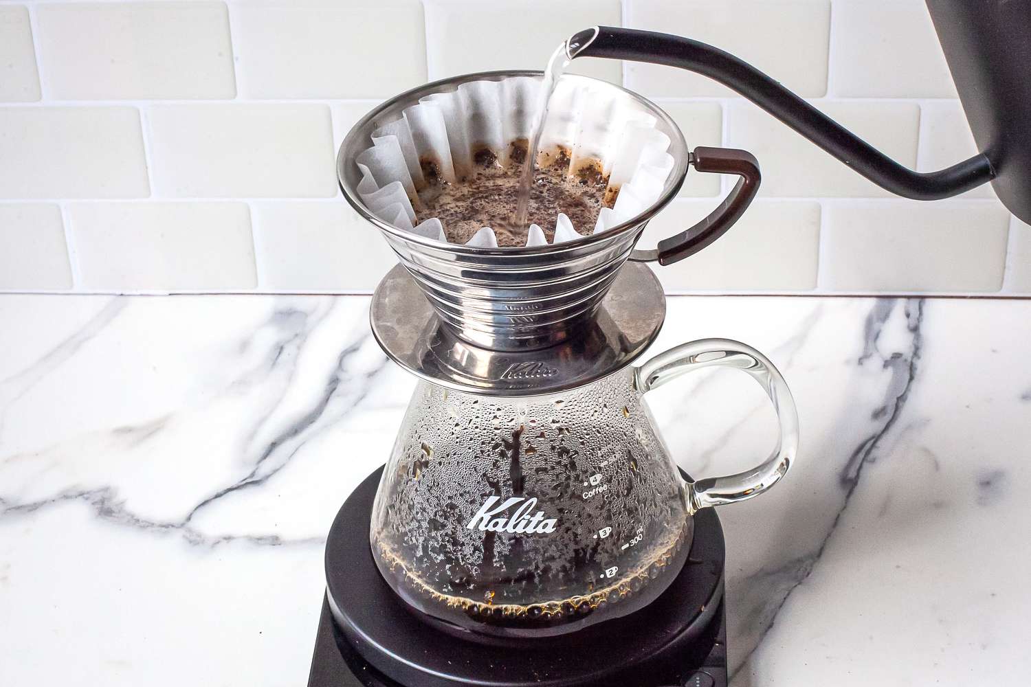 Pour-over coffee brewing setup with water being poured