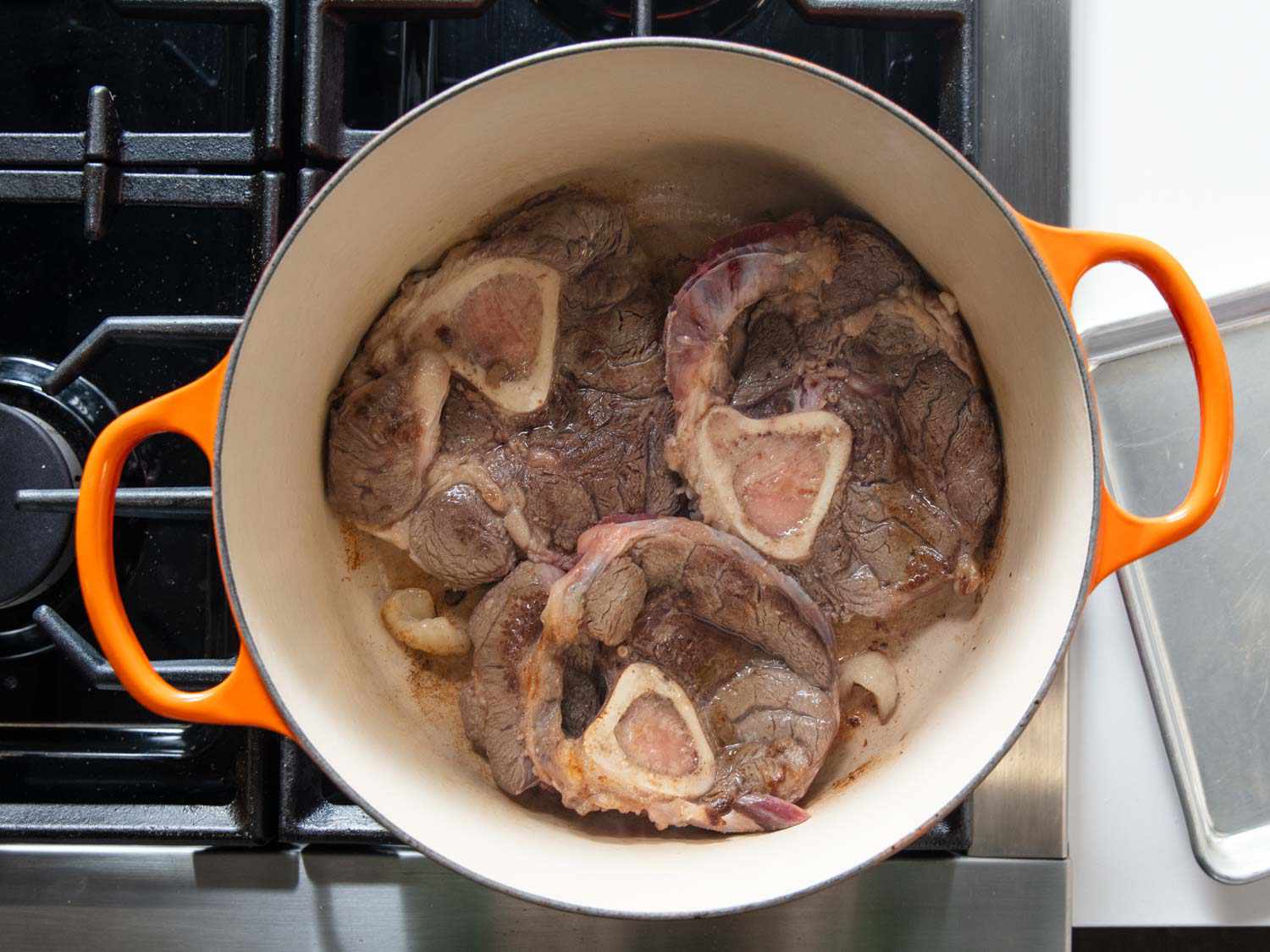 Browning cross-cut beef shin in a Dutch oven.