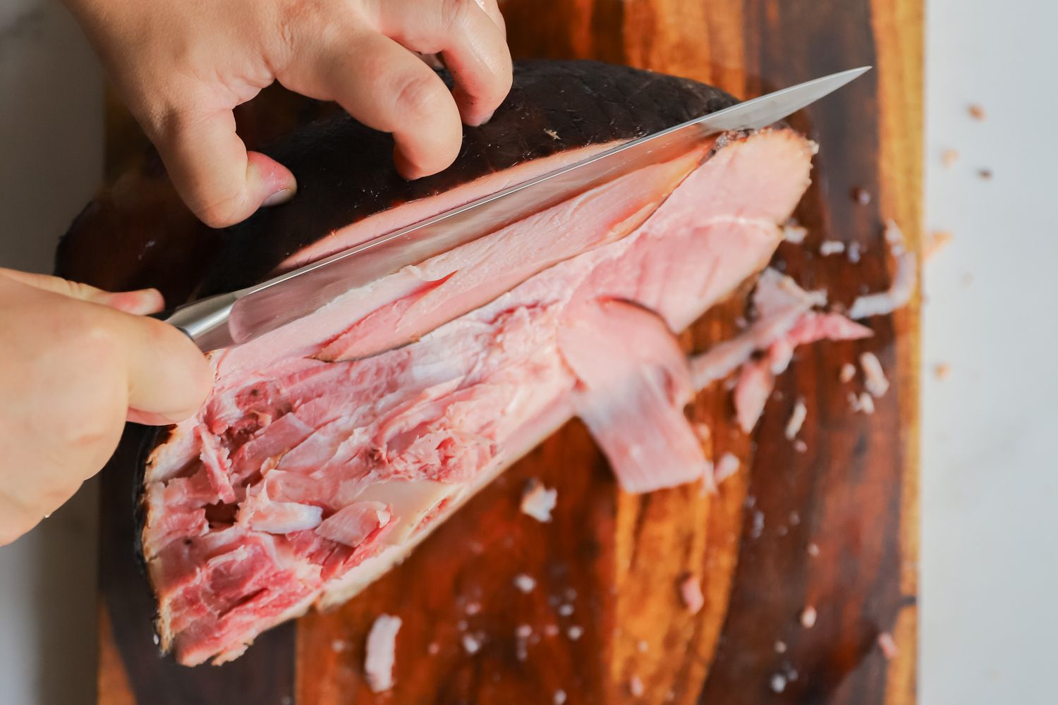 A person slicing meat using the Wusthof Classic Carving Knife