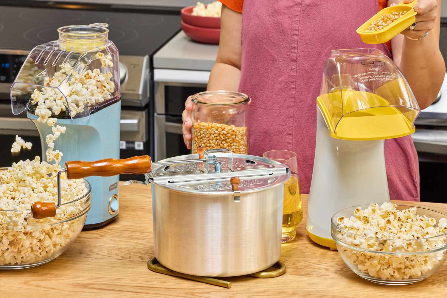 Three popcorn makers on a kitchen countertop.