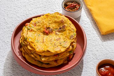 A plate of savory pancakes served with condiments on a table