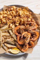 A large platter of fritto misto di mare with fried shrimp, squid, and smelt.