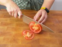 a person using the misen knife to slice a tomato