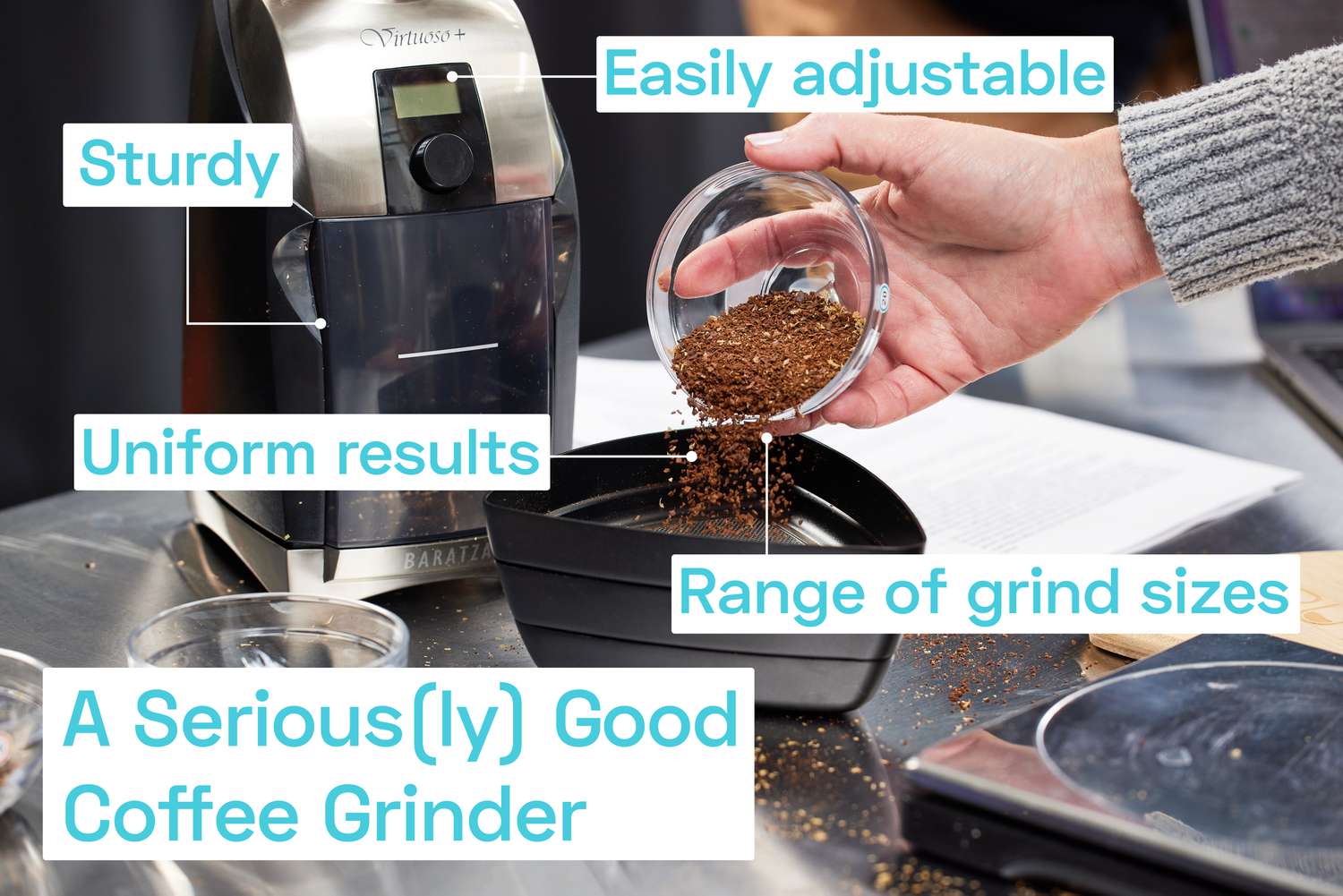 A person pouring coffee grinds into a grinds sifter in front of a coffee grinder.