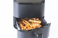 French fries in the open tray of a black air fryer