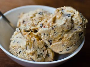 Closeup of a triple scoop of better than Snickers ice cream, served in a white bowl.