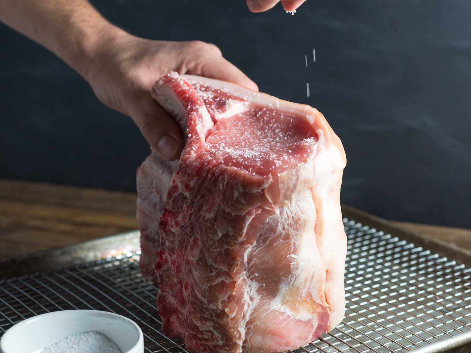 Seasoning a whole raw pork loin with salt