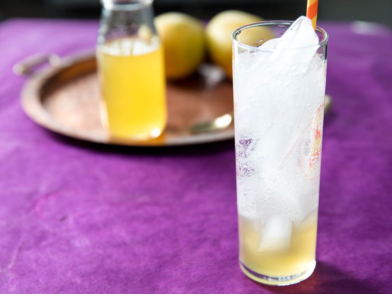 Fresh mango syrup layered on the bottom of tall glass with ice and sparkling water.