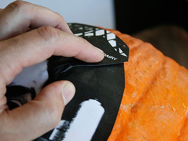 Taping a photo to the outside of a pumpkin