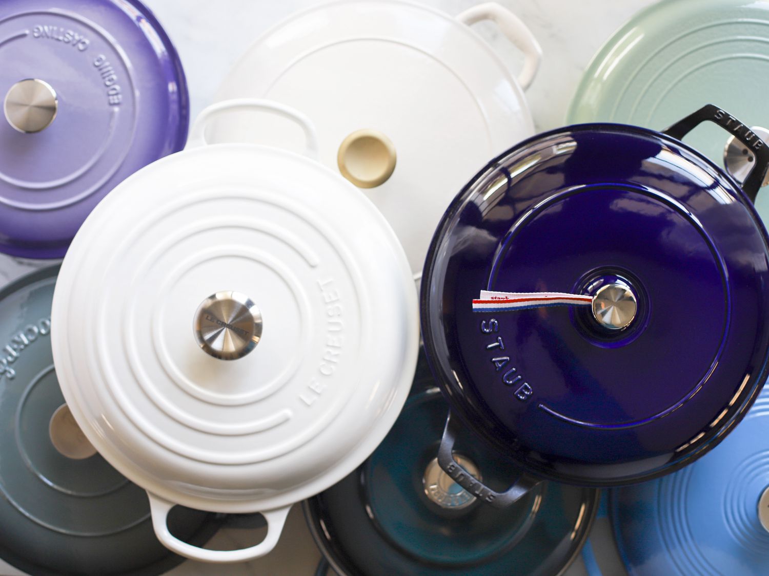 several braisers on a marble surface, with two stacked on top of the others