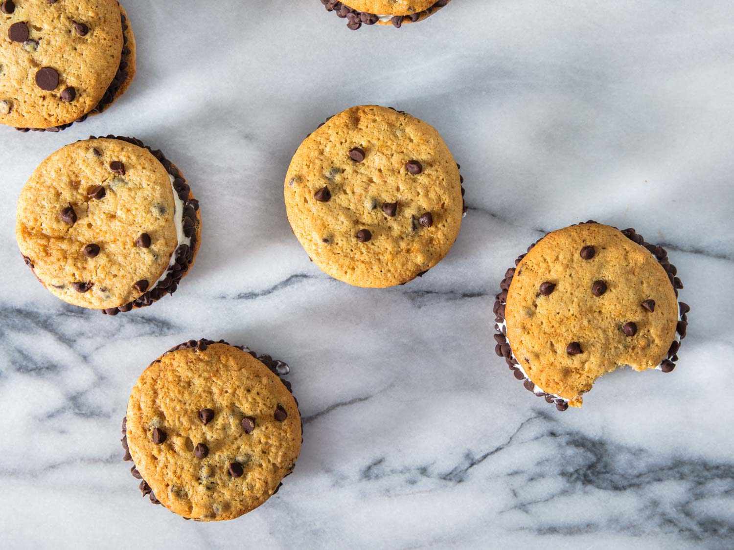 Overhead view of homemade Chipwiches arranged on a white marble surface.