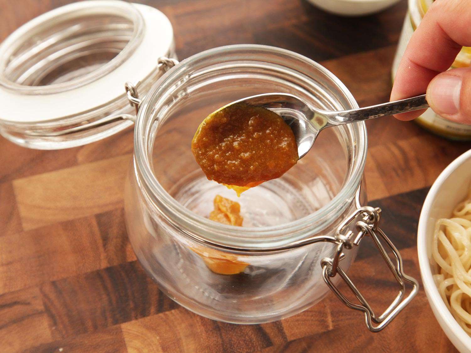 Broth base is spooned into a flip top jar.