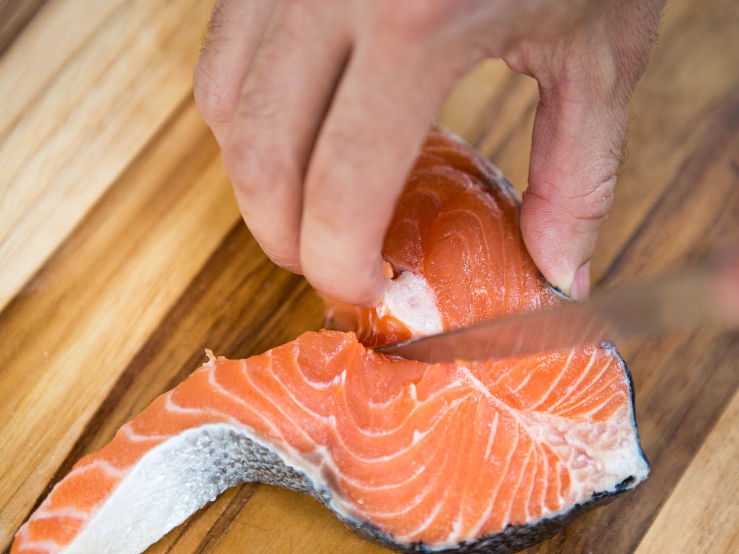 Cutting up towards the spine bone in a salmon steak.