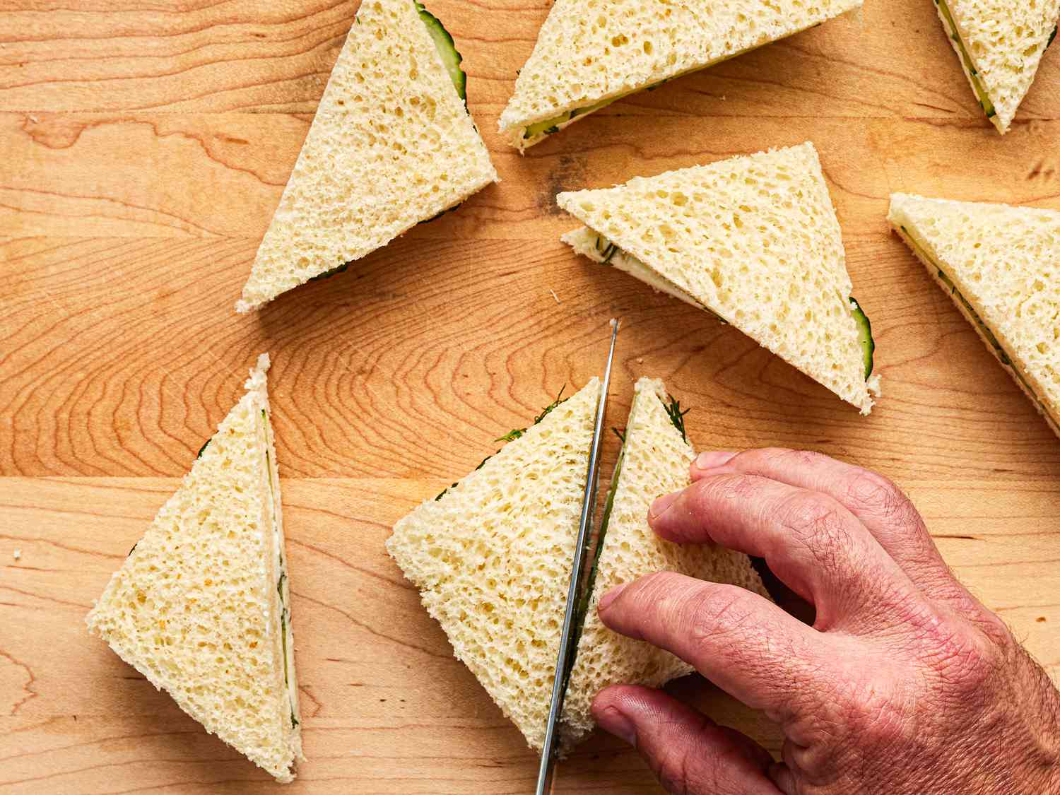 Overhead view of cutting sandwiches into triangles