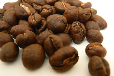 A pile of peaberry beans on a white surface 