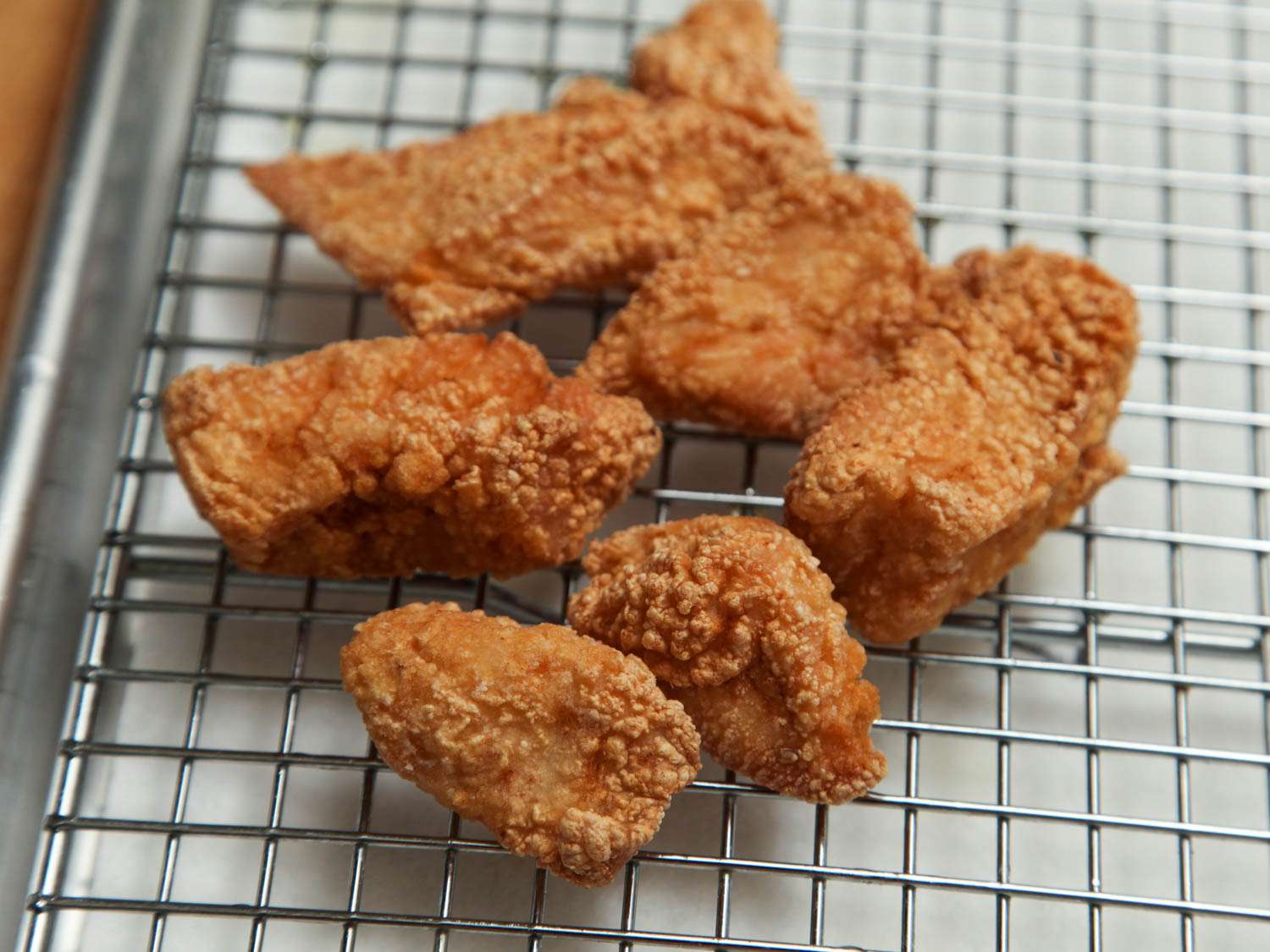 Boneless chicken thighs coated in a liquid marinade and dry cornstarch before frying.