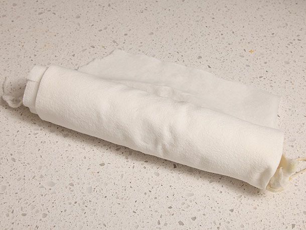 Poached foie gras torchon being dried in paper towel, prepared to be cured again. 