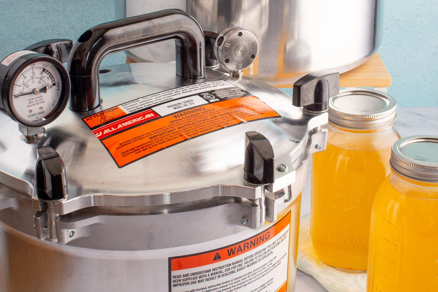 All American 15.5 Quart Pressure Canner next to two jars of broth