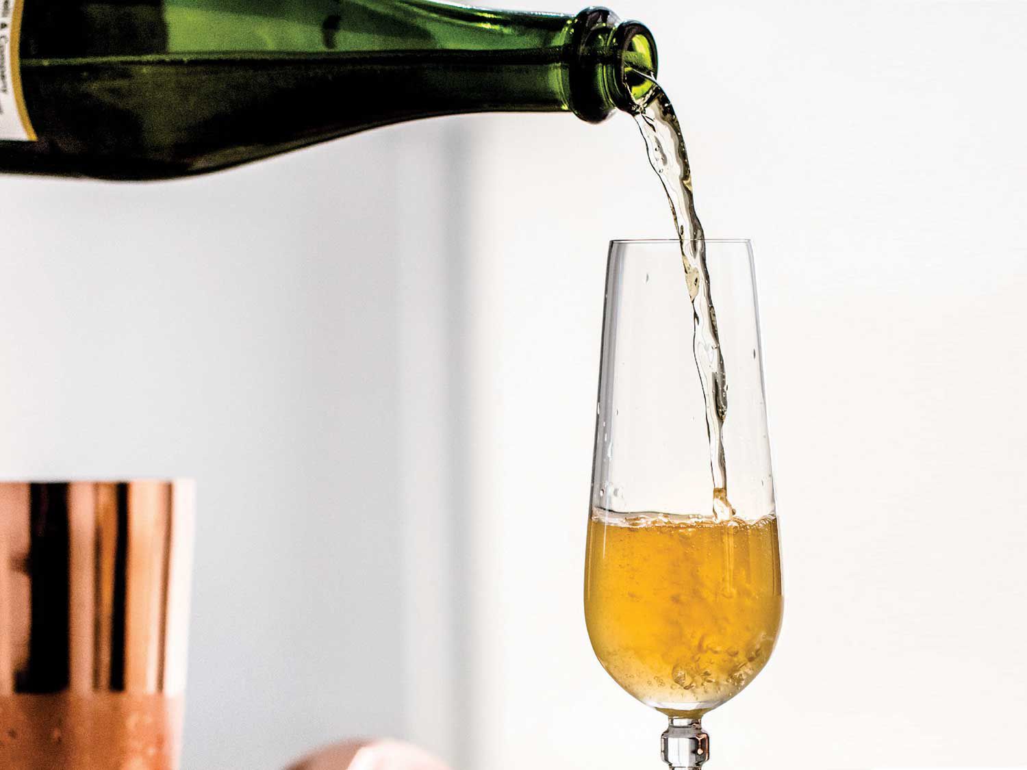 Pouring sparkling apple cider into a Champagne flute.