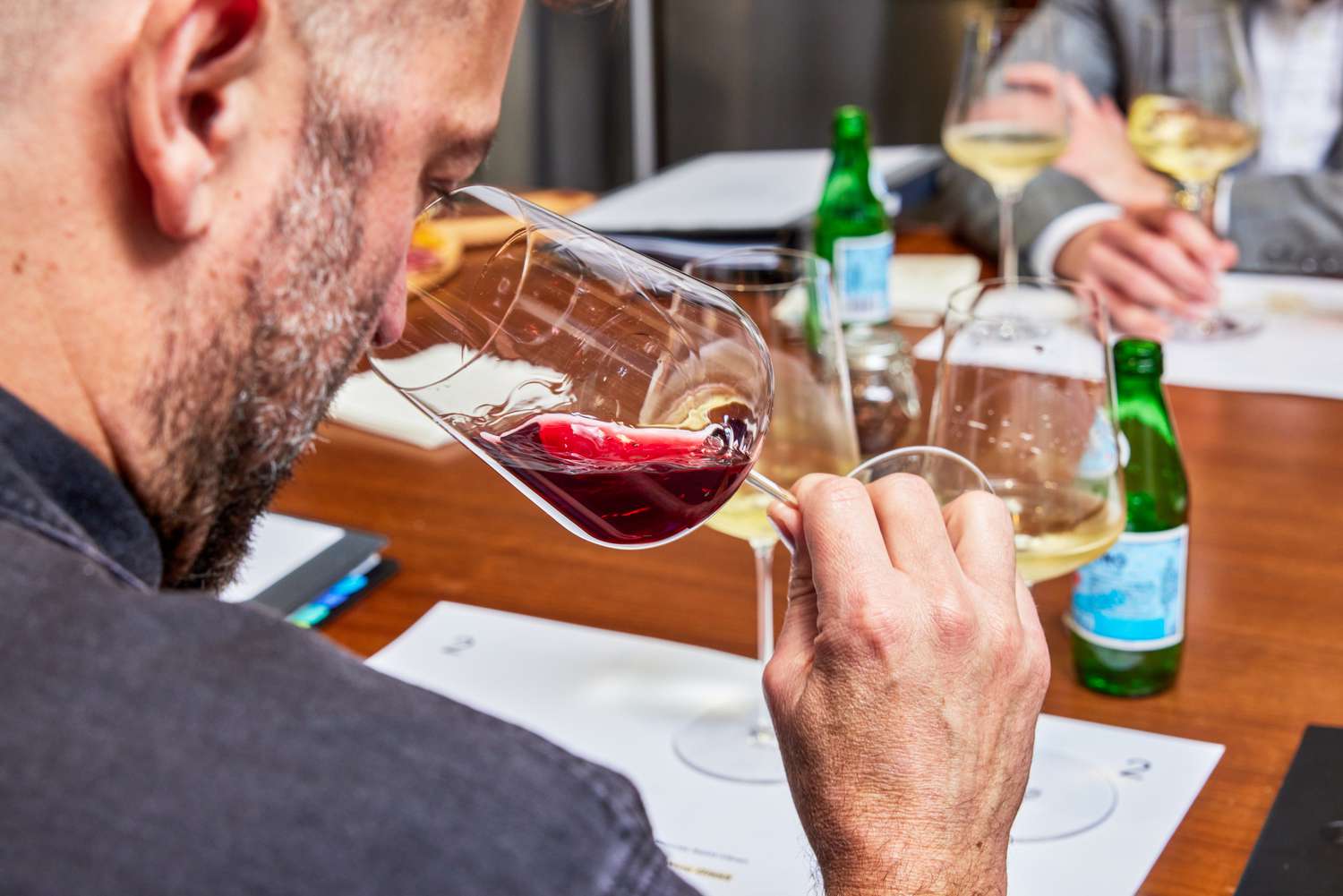 Person sniffing red wine from Zalto Denk'Art Universal Hand-Blown Wine Glass while holding it by the stem