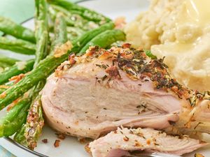Plate of herbed chicken drumsticks green beans and mashed potatoes