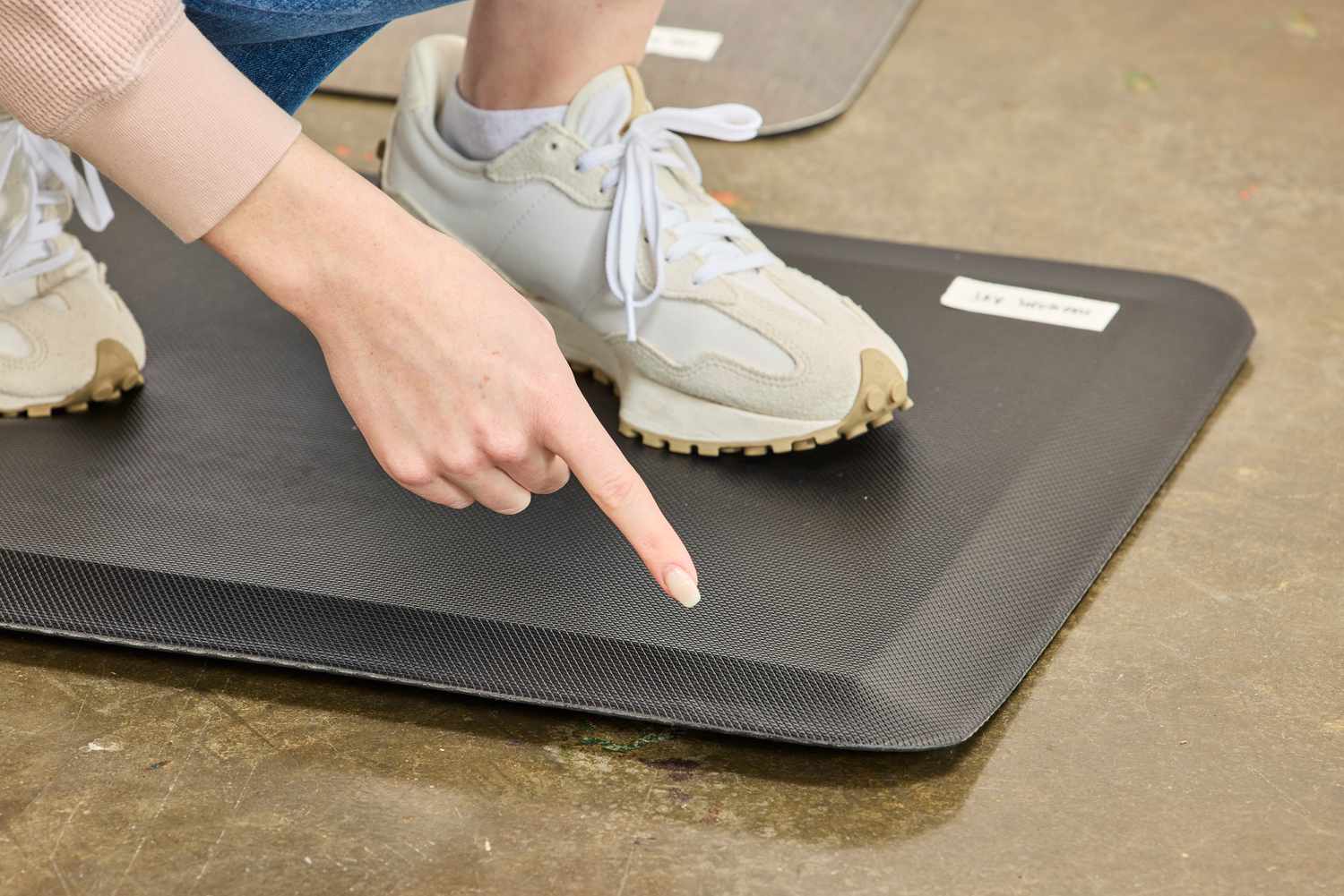A person points to the corner of the Sky Solutions Sky Mat 0.75-Inch Comfort Anti-Fatigue Mat