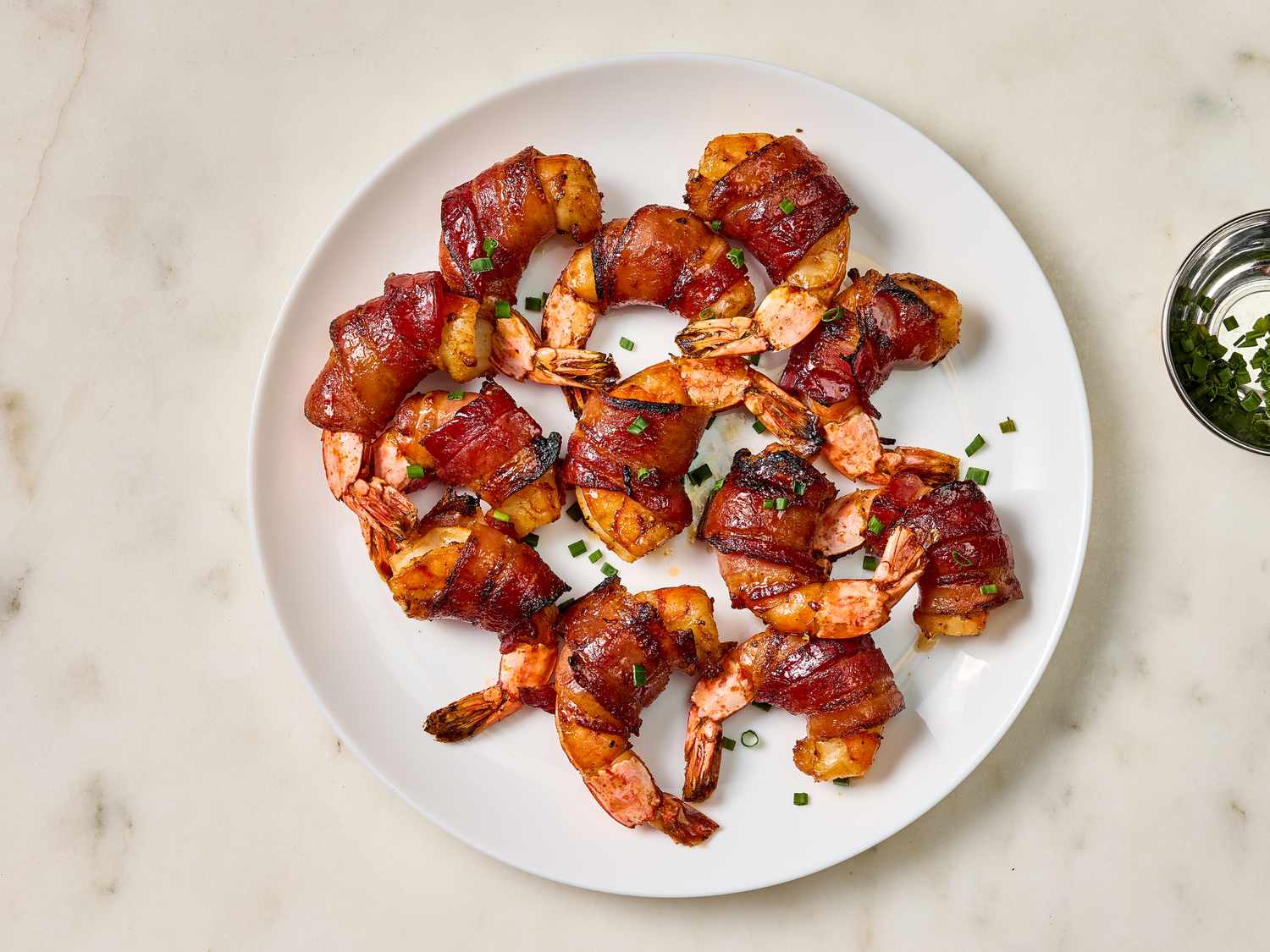 Cooked shrimp on a white plate on a marble surface 