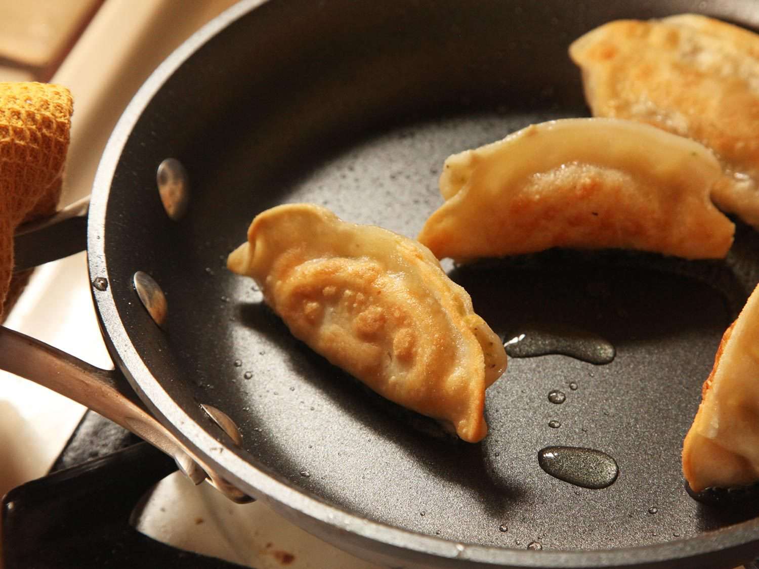 Crisping dumplings in pan.