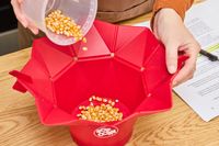 Popcorn kernels are poured into the Chef'n Pop Top Microwave Popcorn Maker