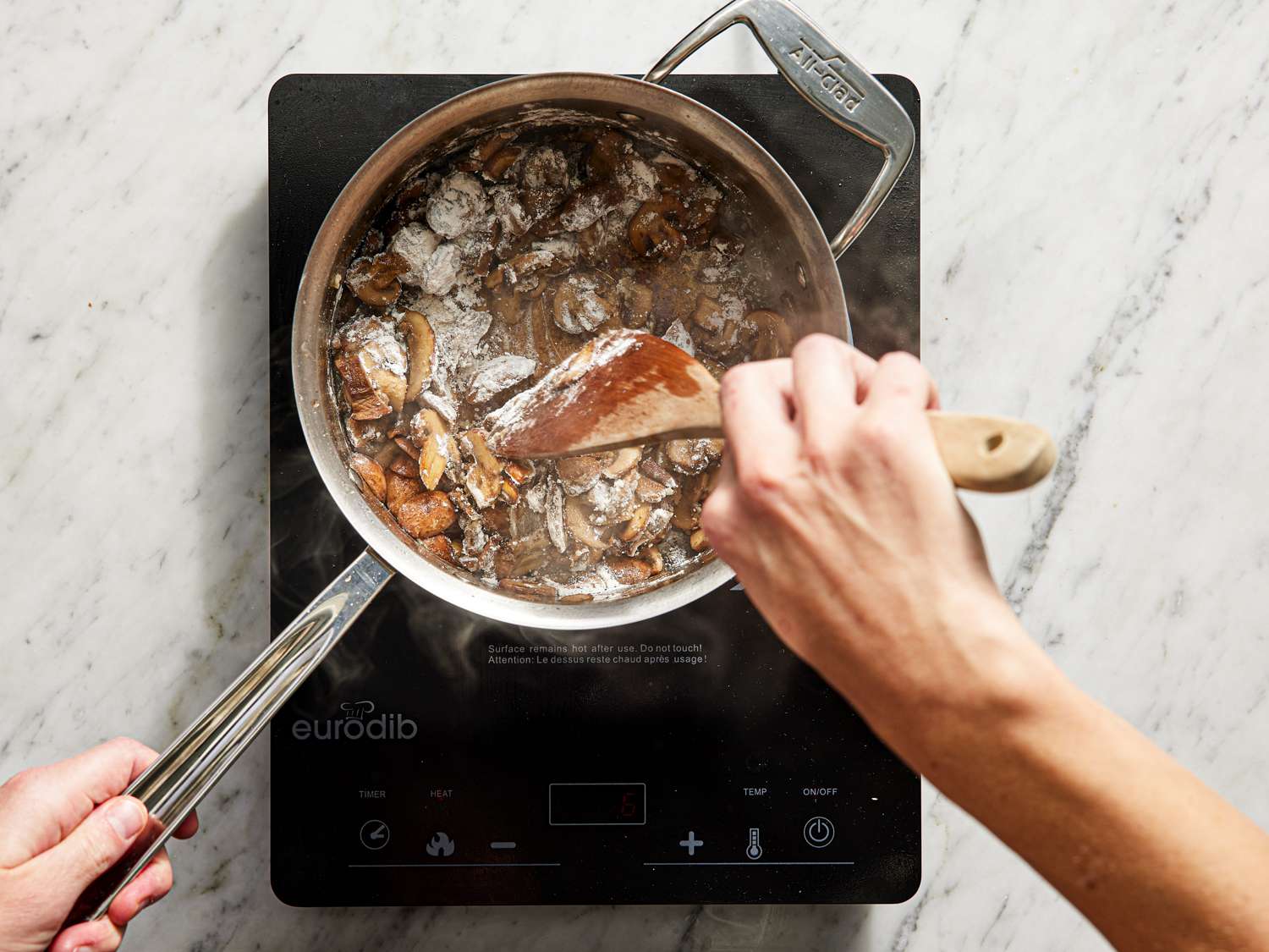 Flour added to mushrooms in saucepan