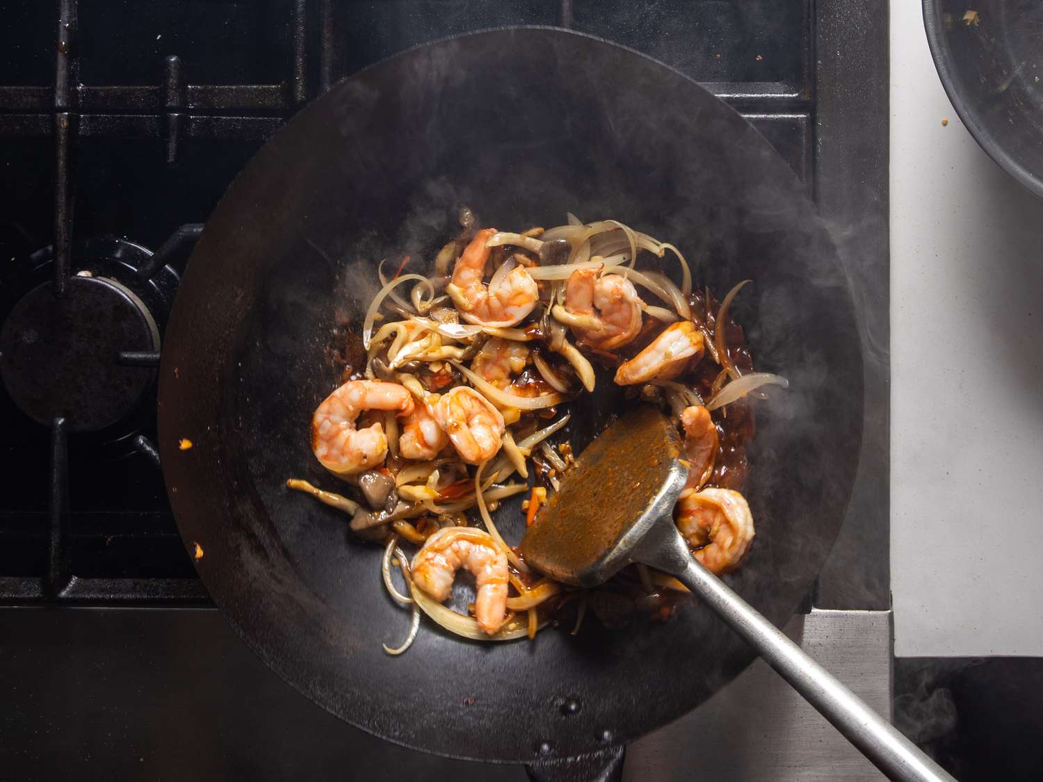 Shrimp being stir-fried in a wok