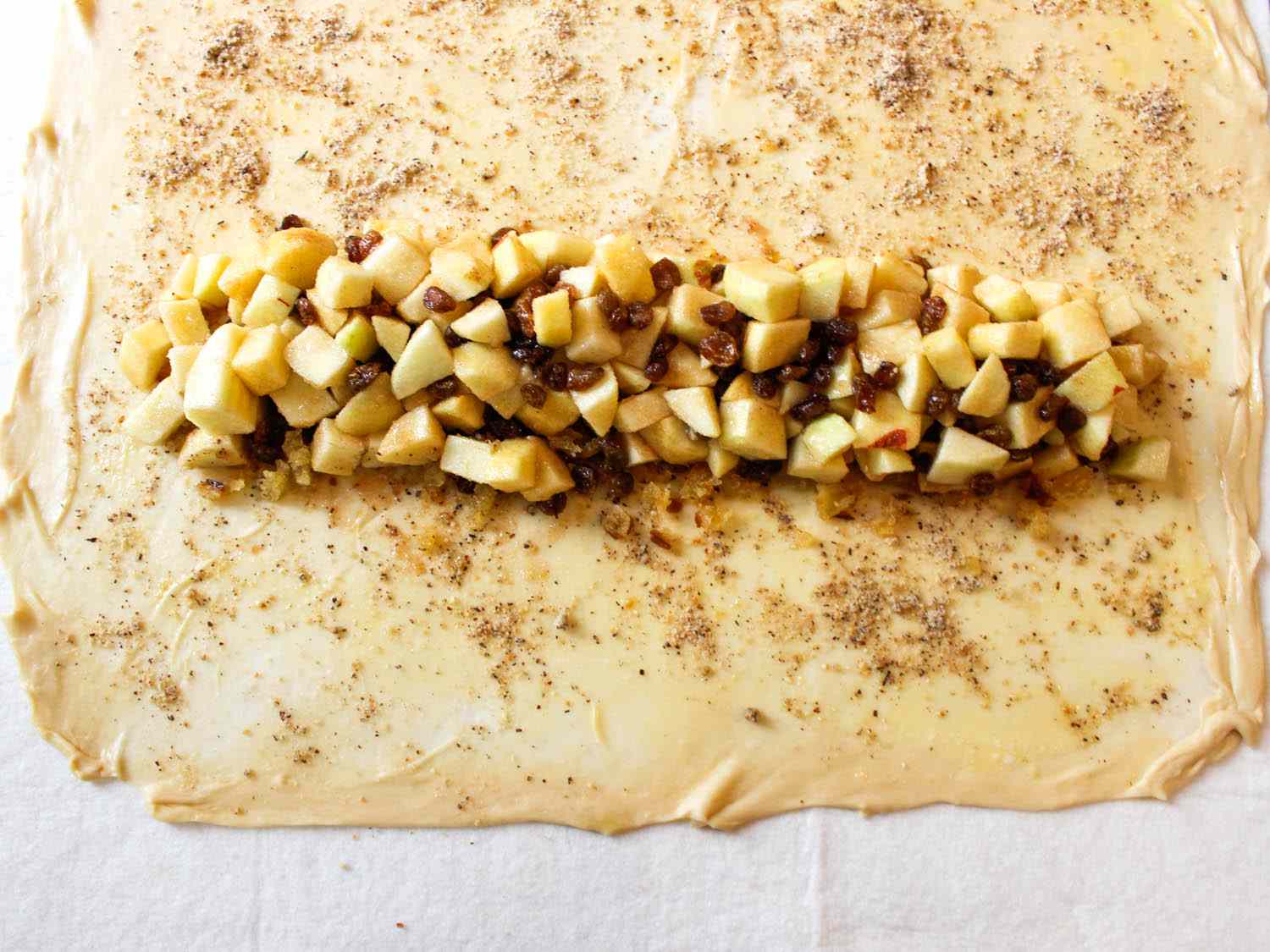 The filling is added to the "bottom" of the rolled out dough with ample margins on the three closest sides.