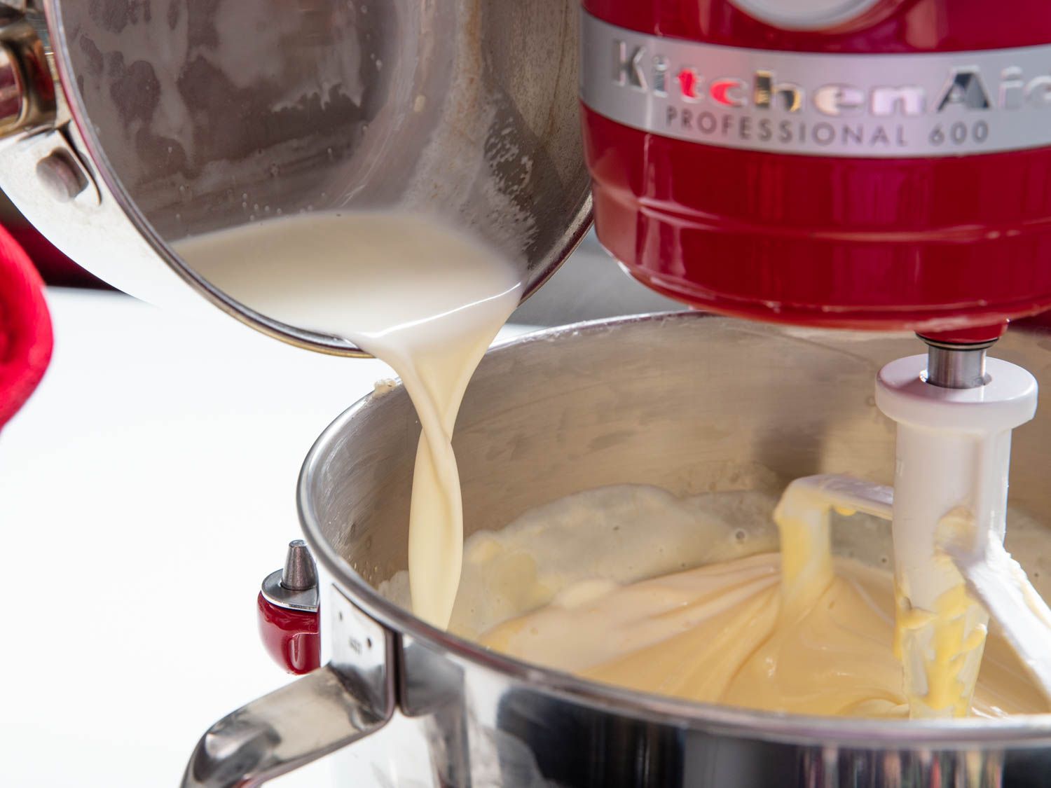 Hot cream is added to the cheesecake batter with the mixer on.