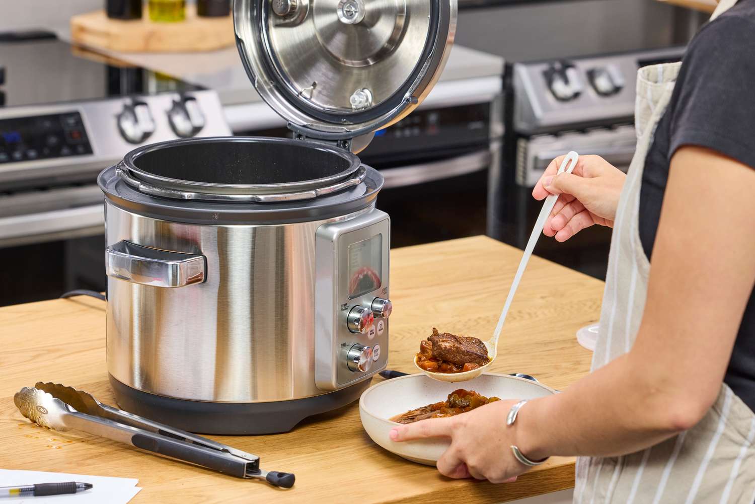 A person examines food cooked in the Breville the Fast Slow Pro