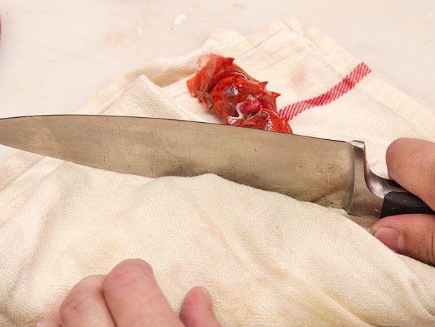 Hitting a cooked lobster claw with the back side of a knife to crack it