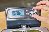 A hand adjusting the control knob on the Breville BDF500XL Smart Fryer