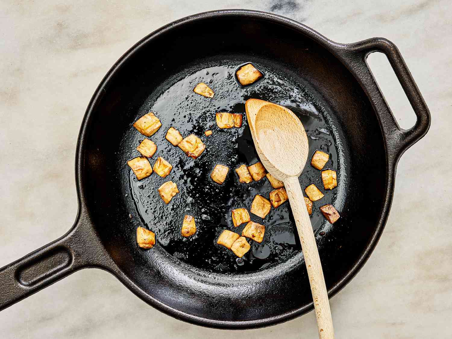 Mushroom stems cooking in a skillet until browned 