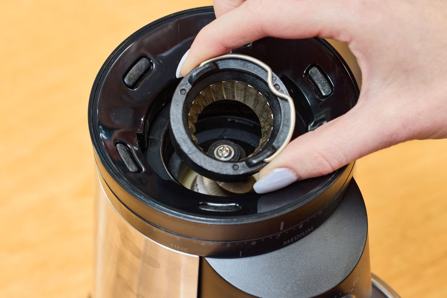 A person removes a part from the OXO Brew Conical Burr Coffee Grinder