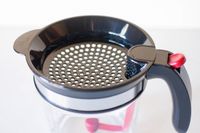 A perforated lid with a handle for a kitchen container or tool