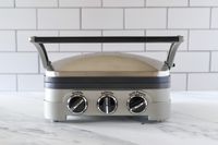 The Cuisinart Griddler panini press on a marble kitchen countertop.
