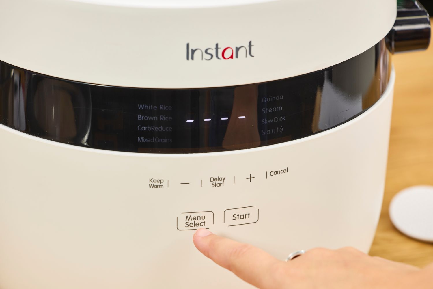 A person presses a button on the Instant Pot 20 Cup Multigrain Cooker