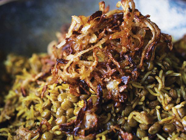 A pile of mejadra topped with freshly fried onions. 