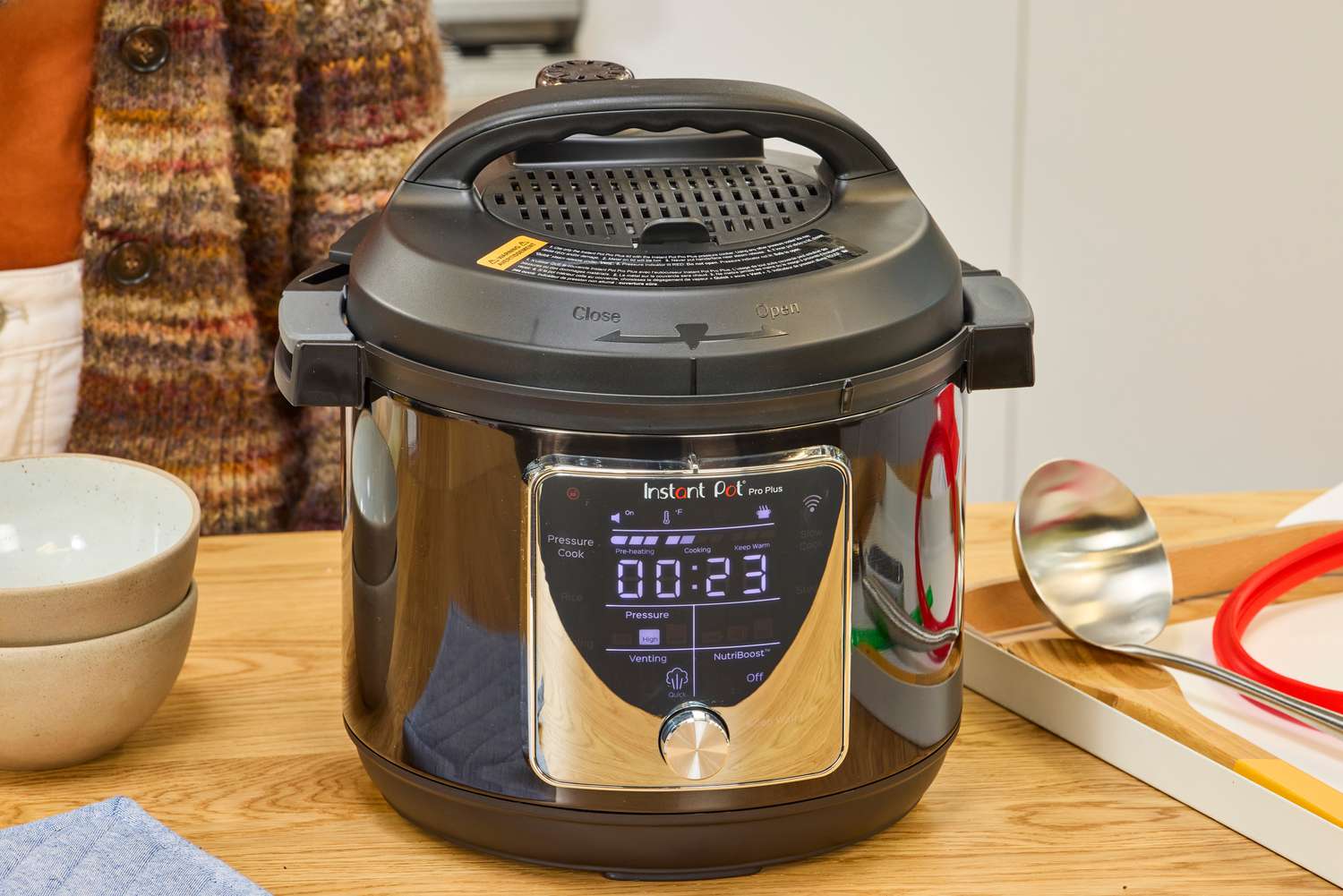 The Instant Pot Pro Plus Wi-Fi Smart 10-in-1 6-Quart Pressure Cooker on a wooden table