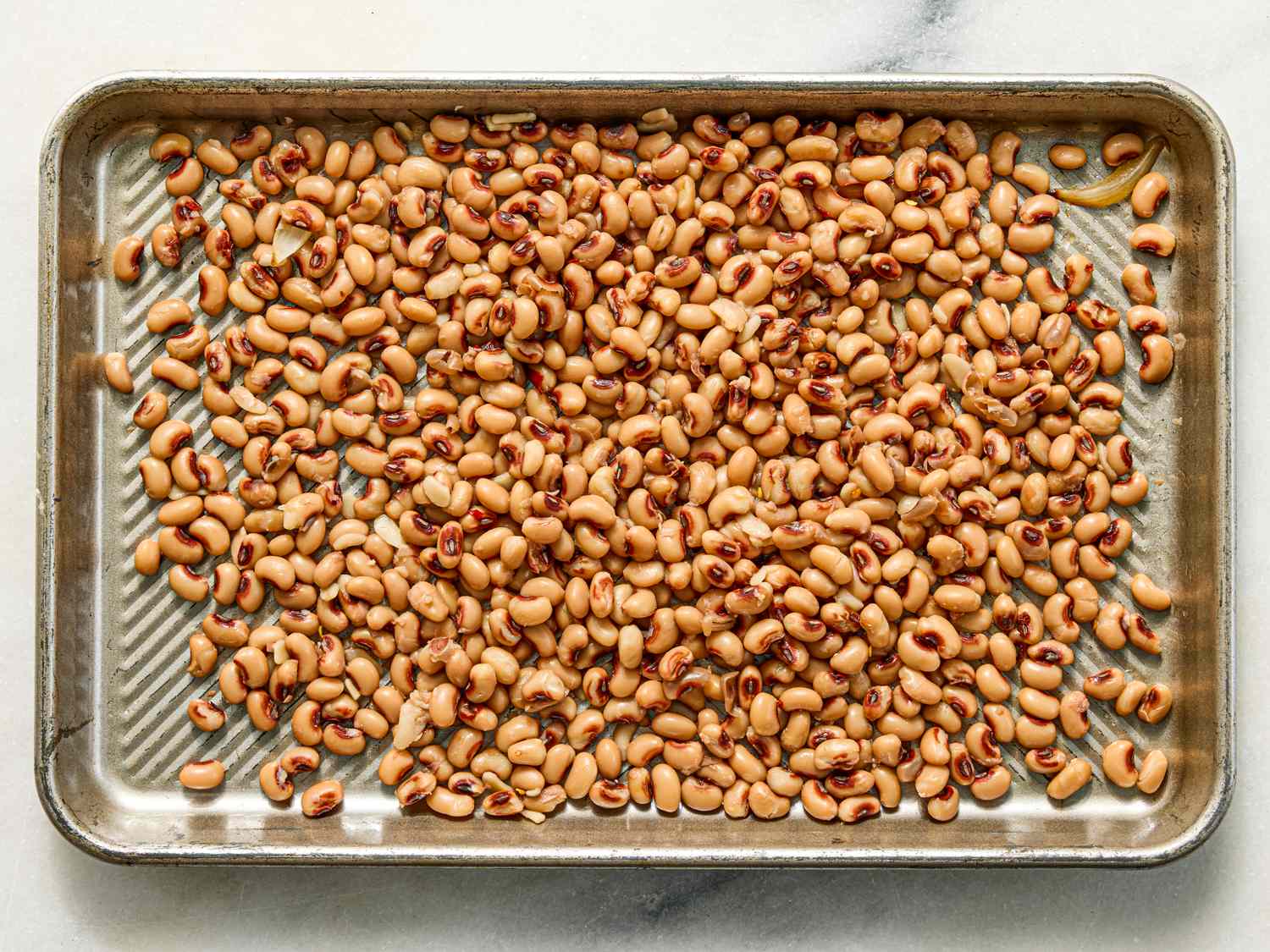 A tray containing blackeyed peas evenly spread out