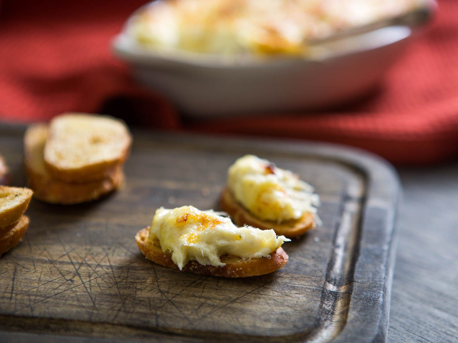 Brandade spread on toasted bread, placed on a wooden cutting board.