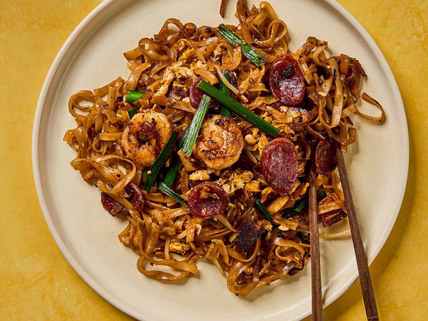 Plate of char kway teow with noodles shrimp and Chinese sausage