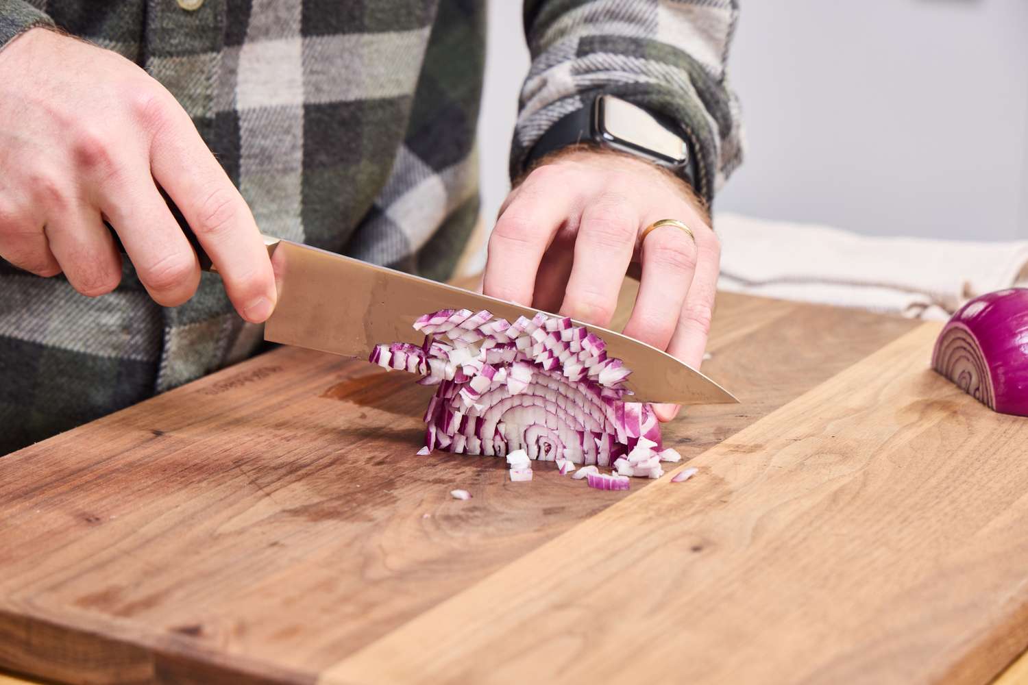 A person dicing an onion with the Misono UX10 Chef’s Knife No. 712