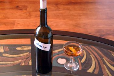A bottle of homemade Italian-style amaro next to a cocktail