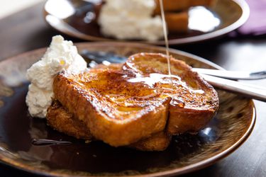 Orange-rum challah French toast, served with whipped crème fraîche and drizzled with maple syrup.