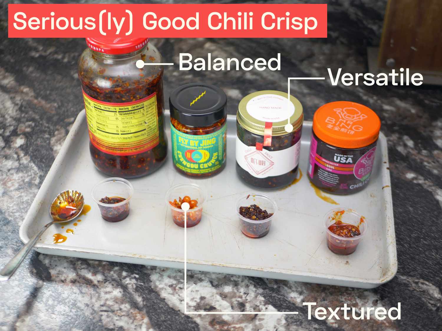 A variety of jars of chili crisp with small plastic cups full of each for tasting